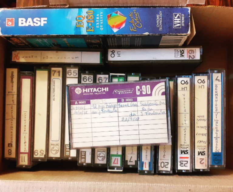 Caja con una colección de casetes y cintas de audio analógico